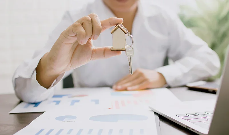 A woman holding house keys getting insurance