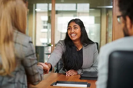 A woman shaking hands in a job interview - listing