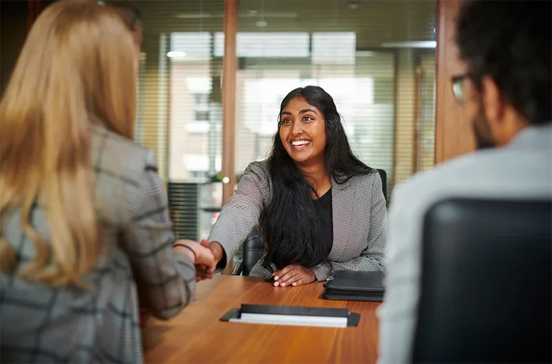 A woman shaking hands in a job interview