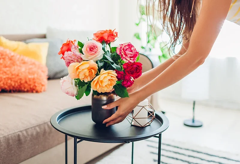 KSS flowers in a vase with a woman placing it