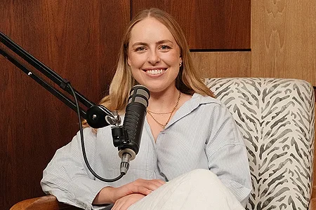 Sarah Kelsey podcasting with a microphone - listing