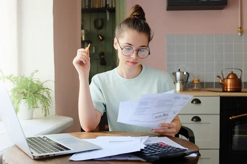 Student female doing some financial budgeting at dining table