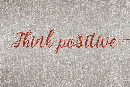 white-concrete-wall-with-text-'think-positive'-written-in-red-cursive-font-article